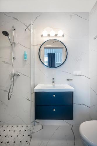 a bathroom with a blue sink and a mirror at W Starym Porcie - pokój z widokiem na Zalew Wiślany balkonem i antresolą in Krynica Morska