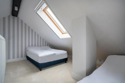 a attic bedroom with a bed and a skylight at W Starym Porcie - pokój z widokiem na Zalew Wiślany balkonem i antresolą in Krynica Morska