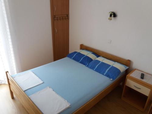 ein kleines Schlafzimmer mit einem blauen Bett und einem Nachttisch in der Unterkunft Apartment Visnja -near Queen Beach in Nin