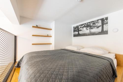 a bedroom with a bed and a wall with a picture at Urban Two-Level Apartments 13 in Tallinn