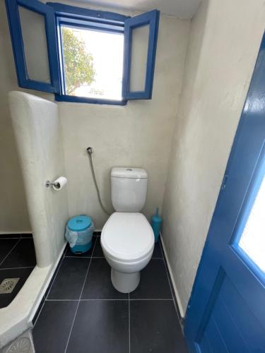 a small bathroom with a toilet with a window at Patmos Horizon in Patmos