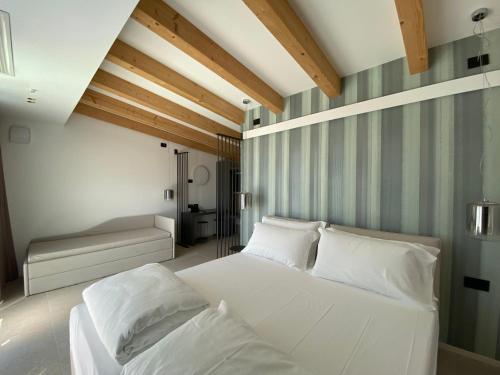 a bedroom with a white bed and a couch at Relais Limonaia - Suites & Garden SPA in Torri del Benaco