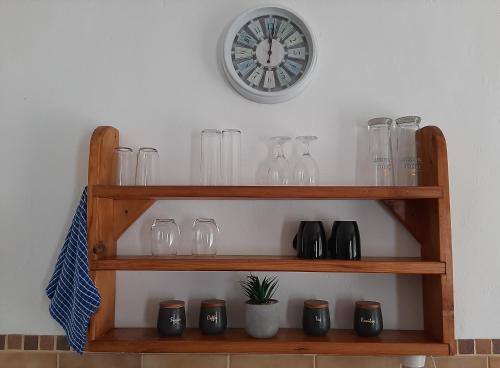 un estante con gafas y un reloj en la pared en In Da Bush, en Modimolle