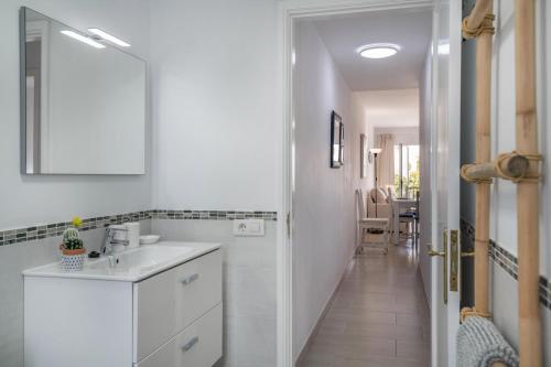 a white bathroom with a sink and a hallway at Alegria in Puerto del Carmen