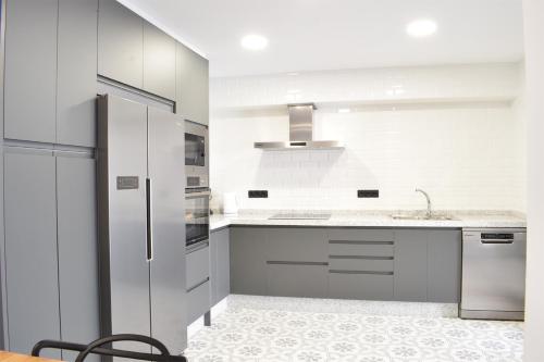 a white kitchen with a sink and a refrigerator at Casa Rural La Lerena in Casar de Cáceres