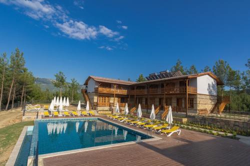 a resort with a swimming pool with chairs and a building at Maison Green Hill in Antalya