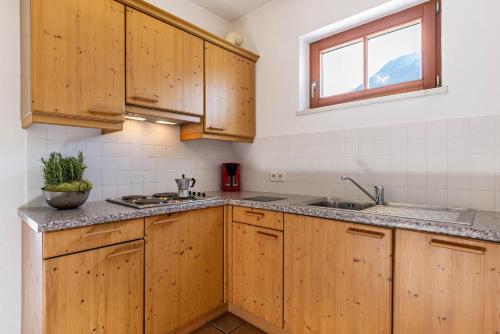 a kitchen with wooden cabinets and a sink and a window at Peintenhof Typ A in Sand in Taufers