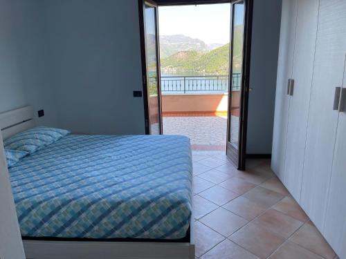 a bedroom with a bed and a view of a balcony at Lake Iseo - Gli ulivi 1 in Sulzano