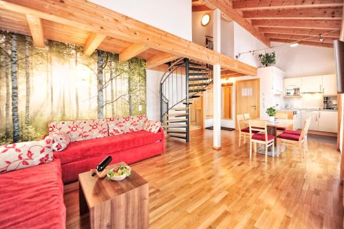 a living room with a red couch and a table at Appartements Plattlerhof in Serfaus