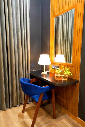 a desk with a blue chair and a mirror at The Nest Luxury Resort in Jaipur