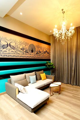 a living room with a couch and a chandelier at The Nest Luxury Resort in Jaipur