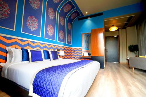 a bedroom with a large bed with blue walls at The Nest Luxury Resort in Jaipur