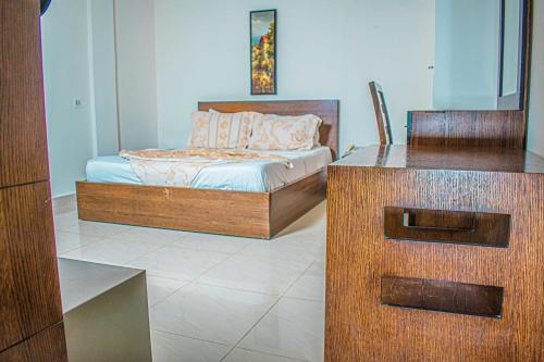 a bedroom with a bed and a desk in it at Hotel Murex in Brazzaville