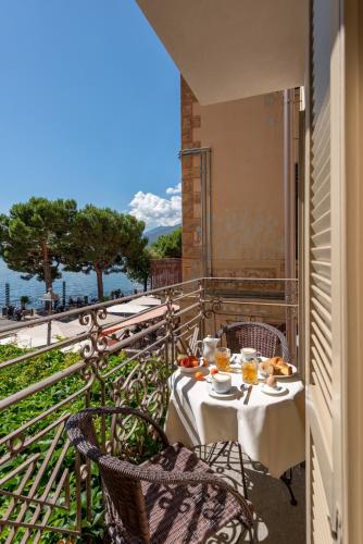 a table with food and drinks on a balcony at Hotel Garni Corona in Menaggio