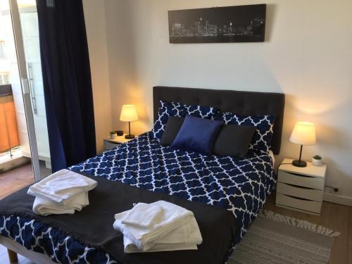 - une chambre avec un lit bleu et blanc et 2 lampes dans l'établissement Chez Marie & Julien, 2 pièces 44m2, à Antibes