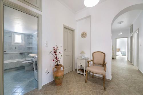 a bathroom with a chair and a toilet and a sink at Panos Villa Asteras in Isterni