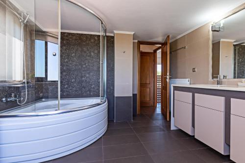 a bathroom with a tub and a sink at Villa Eris in Prinés