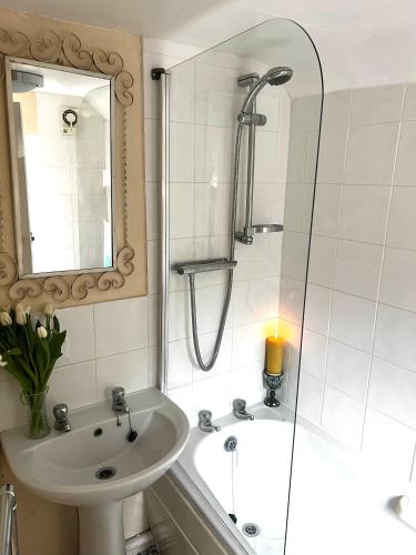 a bathroom with a shower and a sink and a tub at 4 St Richard’s Cottages in Fittleworth
