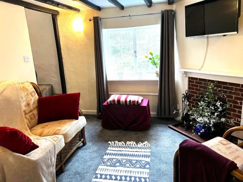 sala de estar con sofá y chimenea en 4 St Richard’s Cottages, en Fittleworth