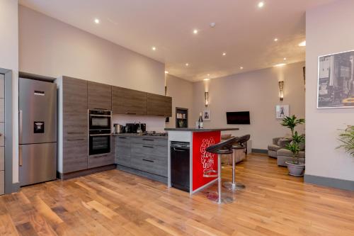 a kitchen with stainless steel appliances and wooden floors at Bohemian luxury accommodation in the heart Edinburghs Leith district in Edinburgh