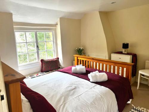 a bedroom with a large bed with two pillows on it at 4 St Richard’s Cottages in Fittleworth