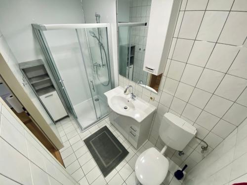 a white bathroom with a toilet and a sink at Apartment Loser im Zentrum in Bad Ischl