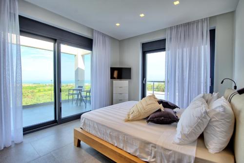 a bedroom with a bed with a view of the ocean at Luxury Villa Ebellina by PosarelliVillas in Acharavi