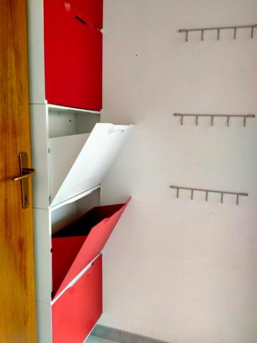 a kitchen with red and white drawers and a door at Apartment in Sardinia in Decimomannu