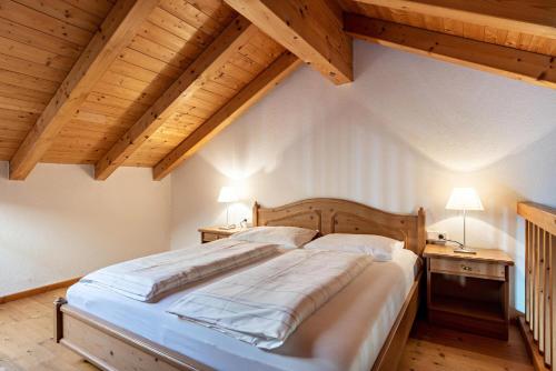 a large bed in a room with wooden ceilings at Peintenhof Typ B in Sand in Taufers