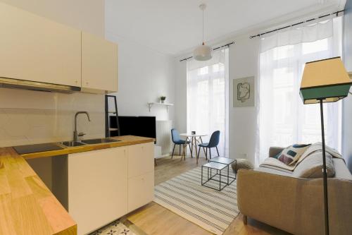 une cuisine et un salon avec un canapé et une table dans l'établissement La suite du Roi - Affaires ou Loisir, à Versailles