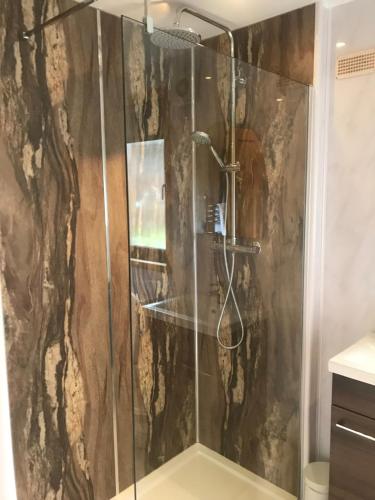 una doccia con porta in vetro in bagno di Lomond Lodge a Rowardennan