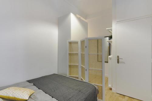 une chambre blanche avec un lit et un placard dans l'établissement La suite du Roi - Affaires ou Loisir, à Versailles