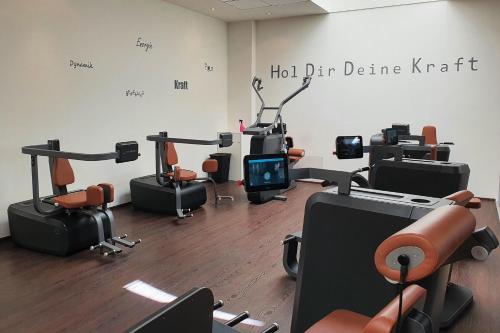 a room with a gym with chairs and machines at Sport Hotel Kenzingen inklusive Schwimmbad, Sauna und Frühstück nähe Europa-Park in Kenzingen
