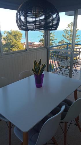 a white table with chairs and a vase on it at PRIMERA LINEA DE PLAYA, VISTAS AL MAr in Benicàssim