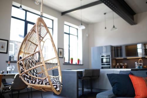 a hanging rattan chair in a living room at Luxury Manhattan loft-style apartment near Edinburgh city centre in Edinburgh