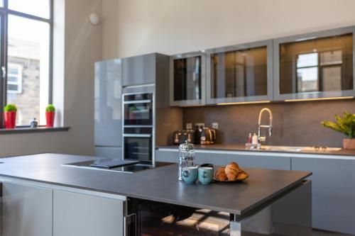 una cucina con tavolo e piatto di cibo di Luxury Manhattan loft-style apartment near Edinburgh city centre a Edimburgo