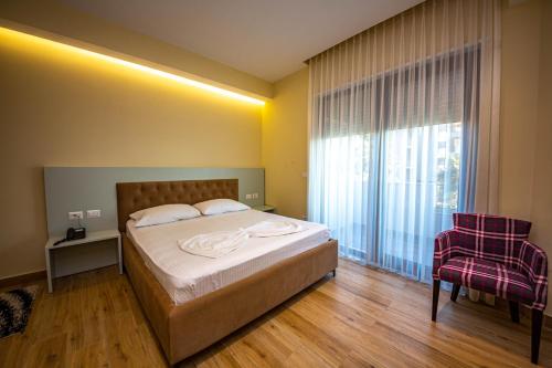 a bedroom with a bed and a large window at Hotel Bella Vista in Durrës