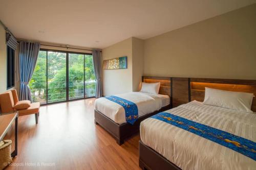 U Thong的住宿－Tolopoti Hotel&Resort，酒店客房设有两张床和窗户。