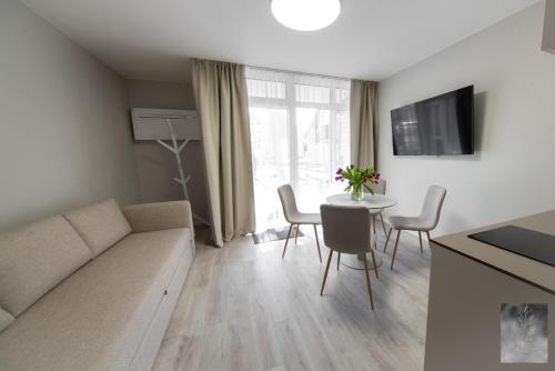 a living room with a couch and a table with chairs at COME2rest - Smilga in Juodkrantė