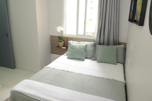 a bedroom with a large bed with green pillows at ACONCHEGO E BEM ESTAR in Brasilia