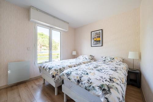 a bedroom with two beds and a window at Le Drive in Saint-Raphaël