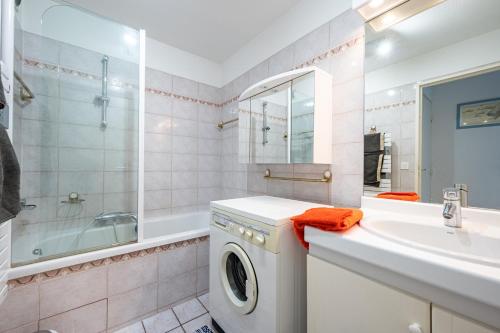 bagno con lavatrice e lavandino di Le Drive a Saint-Raphaël