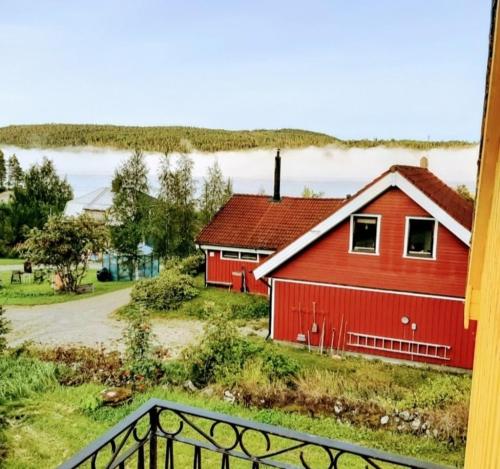 a red barn sitting on top of a field at Cheerful 1-bedroom, 120 m from Sandbach in Bräcke