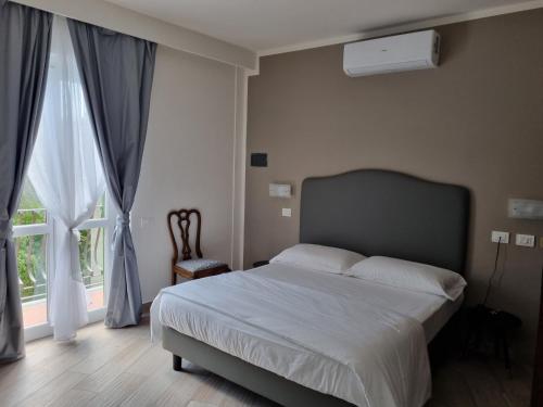 a bedroom with a bed and a large window at Hotel Villa Bonelli in Fiesole