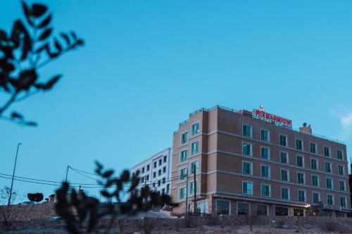 a building with a red sign on top of it at Petra Moon Hotel in Wadi Musa
