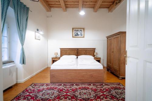 a bedroom with a bed and a dresser and a window at HoStel Cosmopolitan* in Banská Štiavnica