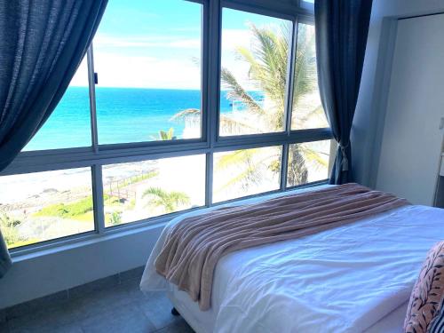 a bedroom with a large window with a view of the beach at Sea View Penthouse in Ballito