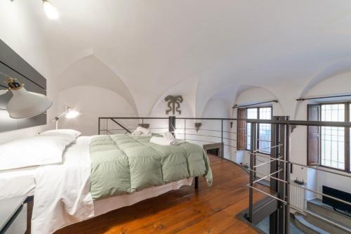 Dormitorio blanco con cama y ventanas en Pepi loft in a historical building, en Florencia