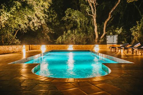 a swimming pool with lights in a backyard at night at Selous Kinga Lodge in Kwangwazi