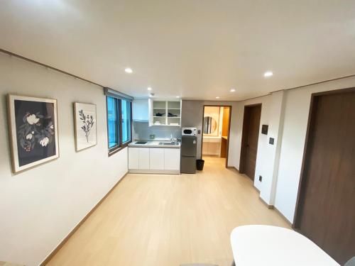 eine Küche mit weißen Wänden und Holzböden in der Unterkunft Luxe & Suite Room in Seoul